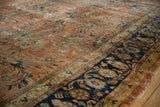 Ornate floral vinery and abrashed dusty terracotta field of a vintage Persian Mahal carpet with deep navy border.