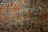 Close view of vintage Persian Mahal carpet, showcasing ornate terracotta floral vinery and worn texture.