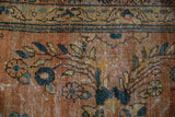 Ornate floral bouquets and vinery in dusty terracotta, navy, and gold on a vintage Mahal carpet, showing wear to knot heads.