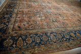 Intricate gold and teal floral vinery on the navy blue border of this vintage Mahal rug.