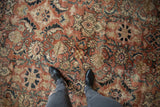 Textured vintage Distressed Mahal rug detail, faded brick red Herati motif, visible wear.