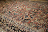 Distressed vintage Mahal carpet detail showing worn brick red pile, beige, and indigo floral vinery.