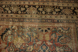 Distressed vintage Mahal carpet showcasing woven brick red, beige, and indigo blue patterns.
