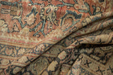 Close-up of distressed Mahal rug's worn texture, showing faded brick red, beige, and dark patterns.