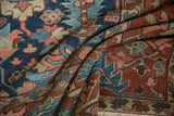 Folded antique Gorevan carpet shows geometric floral pattern in cobalt blue and madder root red.