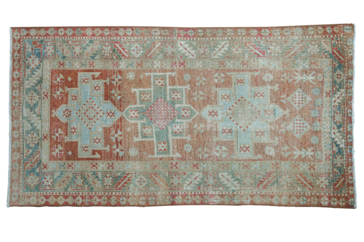 Distressed Persian Karaja rug with a triple medallion design in soft blush, seafoam green, and beige.