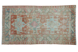 Distressed Persian Karaja rug with a triple medallion design in soft blush, seafoam green, and beige.