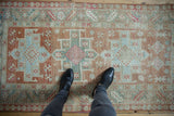 A Karaja rug's central medallion showing even wear with seafoam and dusty blush geometric patterns.
