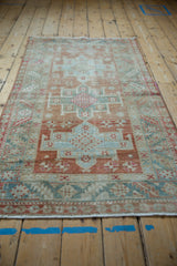 Angled view of a vintage Karaja rug showcasing its faded geometric pattern and muted color palette.