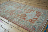 Distressed vintage Karaja rug's geometric medallions and abrashed field viewed from a high angle.