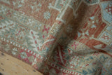 A soft fold revealing the distressed texture and low pile of a vintage Karaja rug.