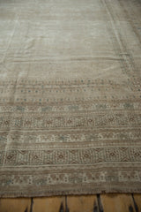 Close-up of distressed Afghan rug's geometric border in beige with slate blue accents.