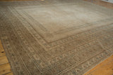 Distressed vintage Afghan rug corner, showcasing geometric borders in muted beige and blue.