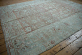 Distressed Malayer rug corner with faded dusty rose, seafoam green traditional patterns.