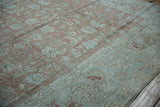 Distressed vintage Malayer border with nuanced floral cross view and serrated leaves.