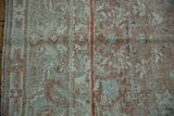 Worn dusty rose and pale green intricate floral patterns on a vintage Malayer rug.