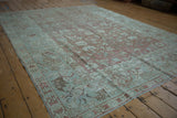 Distressed Malayer corner with wide pale seafoam border, serrated leaf motif, rose field, and fringe.