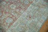 Distressed Malayer carpet detail: dusty rose floral field meets pale seafoam green border.