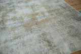 Distressed Meshed carpet's worn texture, with visible foundation, ivory, camel, and faint green hues.