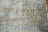 Distressed vintage Meshed rug detail, highlighting low pile, exposed foundation, and faded floral texture.