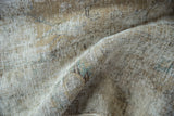 Distressed Meshed carpet texture with visible foundation, subtle camel, ivory, and seafoam colors.