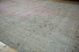 Distressed Meshed carpet with faded pink and ivory tones, faint foundation and arabesque border.