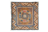 Distressed vintage Ningxia rug with bronze floral medallion and blue, rose geometric borders.