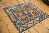Distressed Ningxia rug corner with blue selvage, geometric guls, and worn pile.