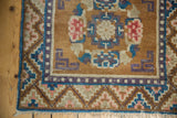 Distressed Ningxia rug corner with pearl motif, dragon stylized guls, and fringed edge.