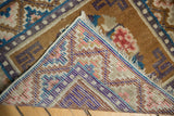 Corner of a vintage distressed Ningxia rug showing its colorful hand-knotted foundation and patterned pile.