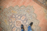 Scalloped medallion with intricate vines and palmettes in faded pink, silver, and denim blue.