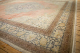 Distressed vintage Kayseri rug corner with time-softened blue and rose floral borders and fringe detail.