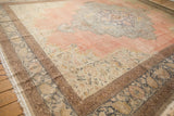 Distressed vintage Kayseri carpet corner with faded rose and blue ornate floral border.