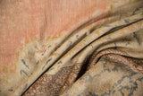 Distressed texture of a vintage Kayseri rug showing faded pink, beige, and intricate patterned border.