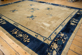Corner of a vintage Peking carpet: cobalt blue pictorial floral border on an ivory field.