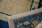 Peking carpet edge, revealing ivory field, blue pictorial border, and intact side selvage.