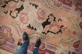 Vintage distressed Khotan carpet, soft blush field, pale violet, and chocolate floral motifs.