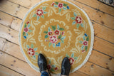 Fringed edge of the Art Deco round rug, with saffron yellow, dusty rose, and green leaves.