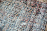 Distressed vintage Baktiari carpet texture, revealing worn knot heads and dusty red, blue, ivory.
