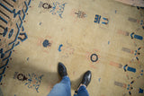 Antique Ningxia pilar carpet with beige field and scattered blue, peach cloudband motifs.