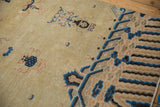 Antique Ningxia pillar carpet detail showing worn pile, cobalt blue cloudbands, and subtle plant motifs on beige.