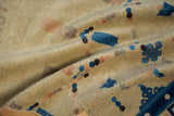 Folded detail of an antique Ningxia carpet: textured beige pile, cobalt blue cloudbands, and peach accents.