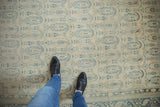Overhead detail of a distressed Sivas carpet's even wear on the dusty blue paisley pattern.