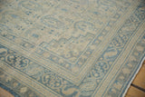 Corner of a vintage Sivas carpet highlighting its even wear, low pile, and blue boteh designs.