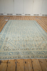 Angled perspective showing the full length of the vintage distressed Sivas carpet laid flat.