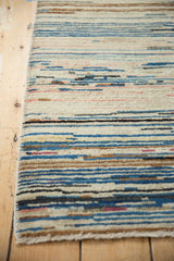 Vintage Peking rug's horizontal striations with banded thickness, showing blues, ivory, peach, and fringe.
