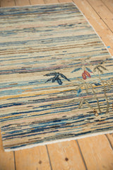 Angled detail of vintage Chinese Peking rug, multicolor horizontal striations and eucalyptus bamboo plant.