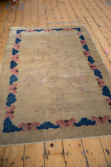 Beige Art Deco rug corner with cobalt blue, blush cloud border, original selvage.