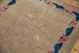Corner of antique Chinese Art Deco rug with pink cherry blossoms and cobalt blue cloud border.