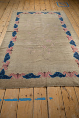 Dusty blush and cobalt blue cloud border on a beige antique Chinese Art Deco rug.